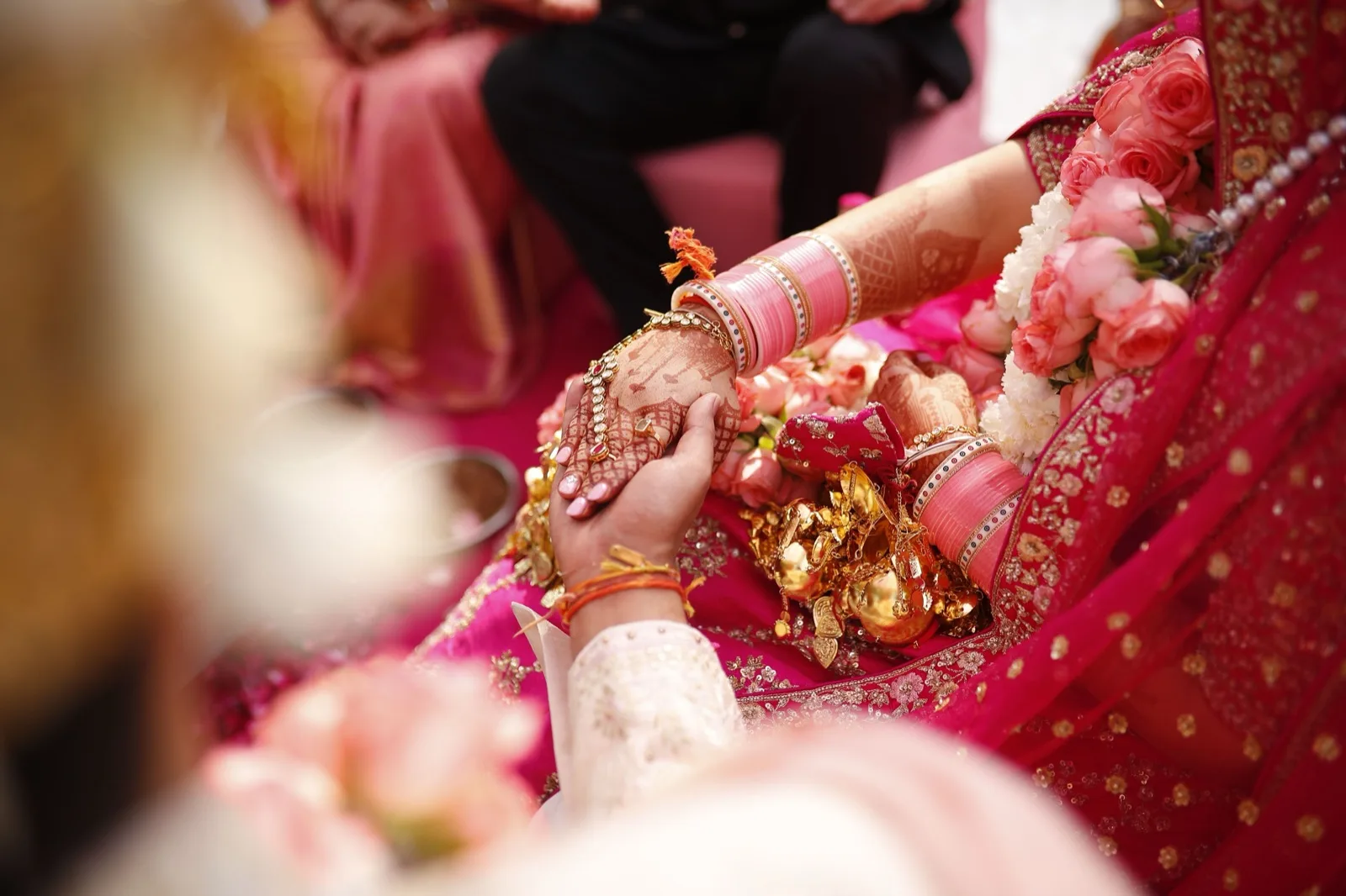 Bride and groom's hands with henna and bangles during the ceremony