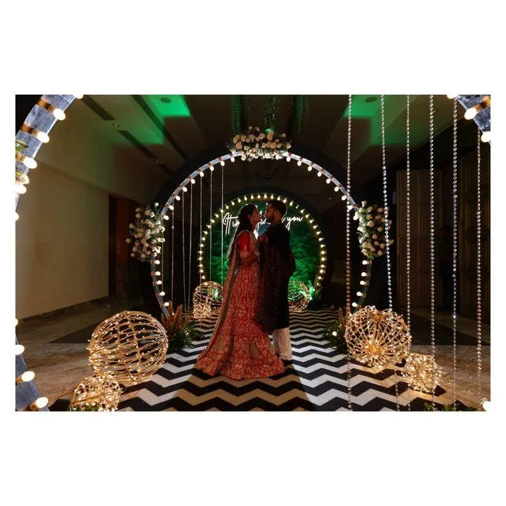 Bride and groom embracing under a lit circular arch