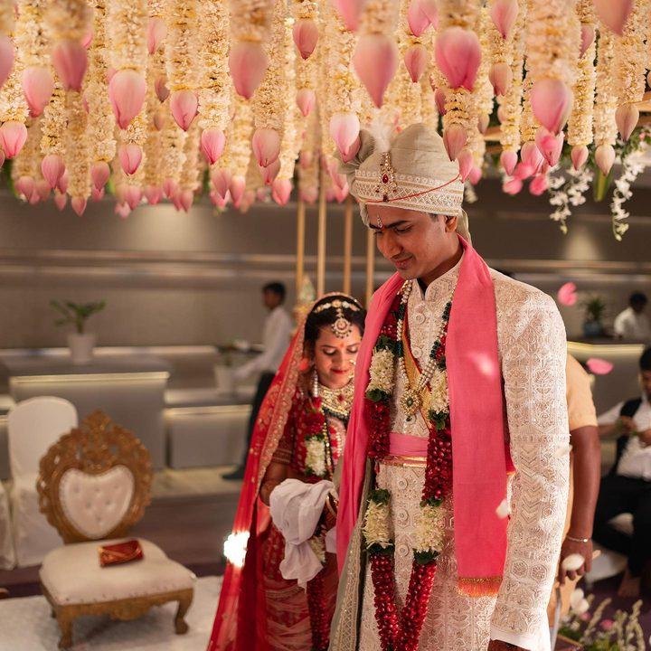 Bride and groom walking beneath a hanging floral ceiling