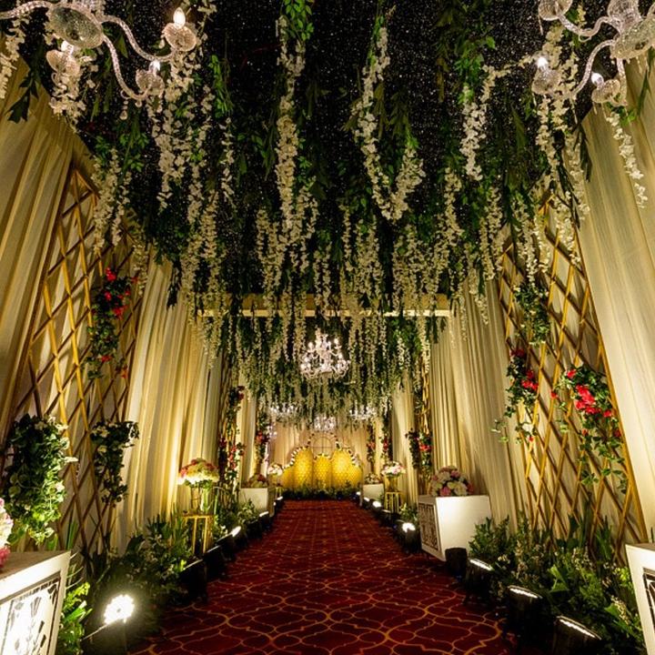 Hanging floral walkway leading to a golden orb stage