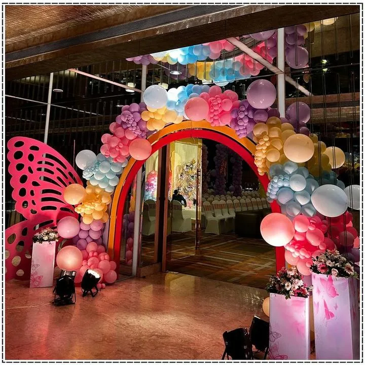 Rainbow balloon arch entrance with a giant butterfly cutout
