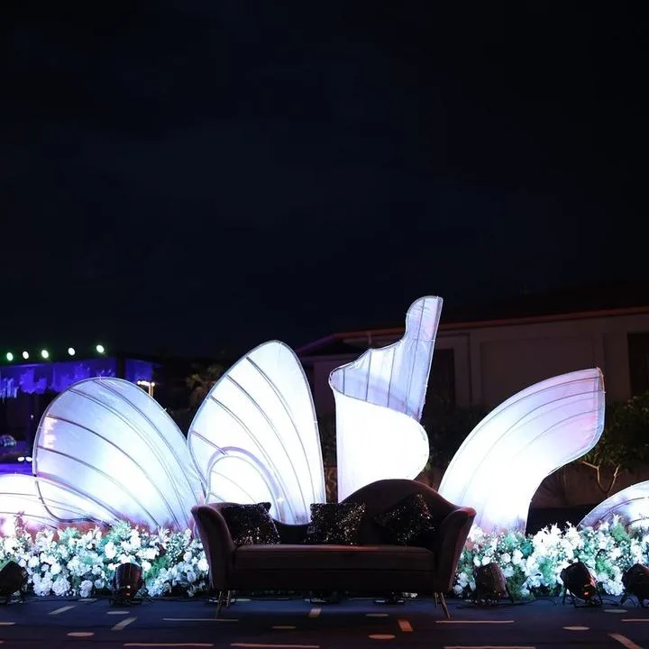 Illuminated sculptural wing backdrop with lounge sofa