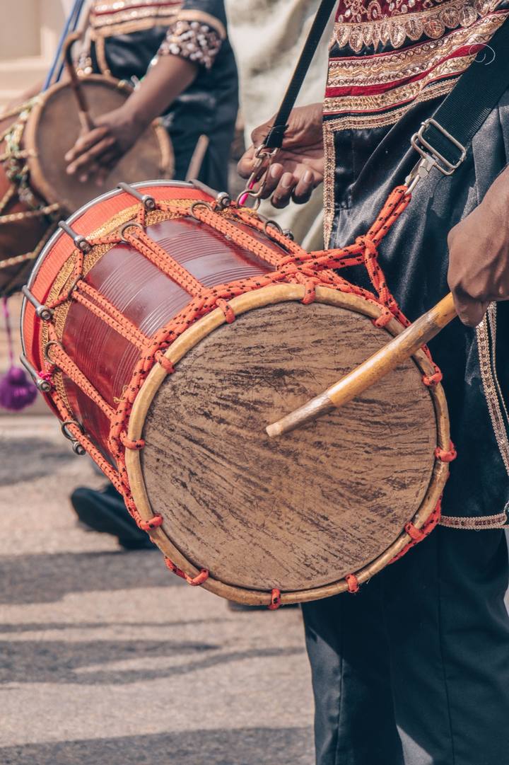 Dhol drummer performing at a wedding celebration